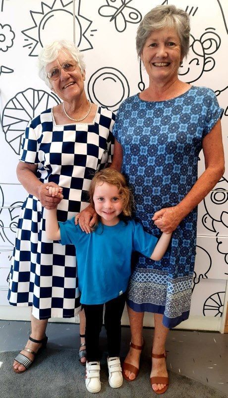 Two older women and a little girl are posing for a picture