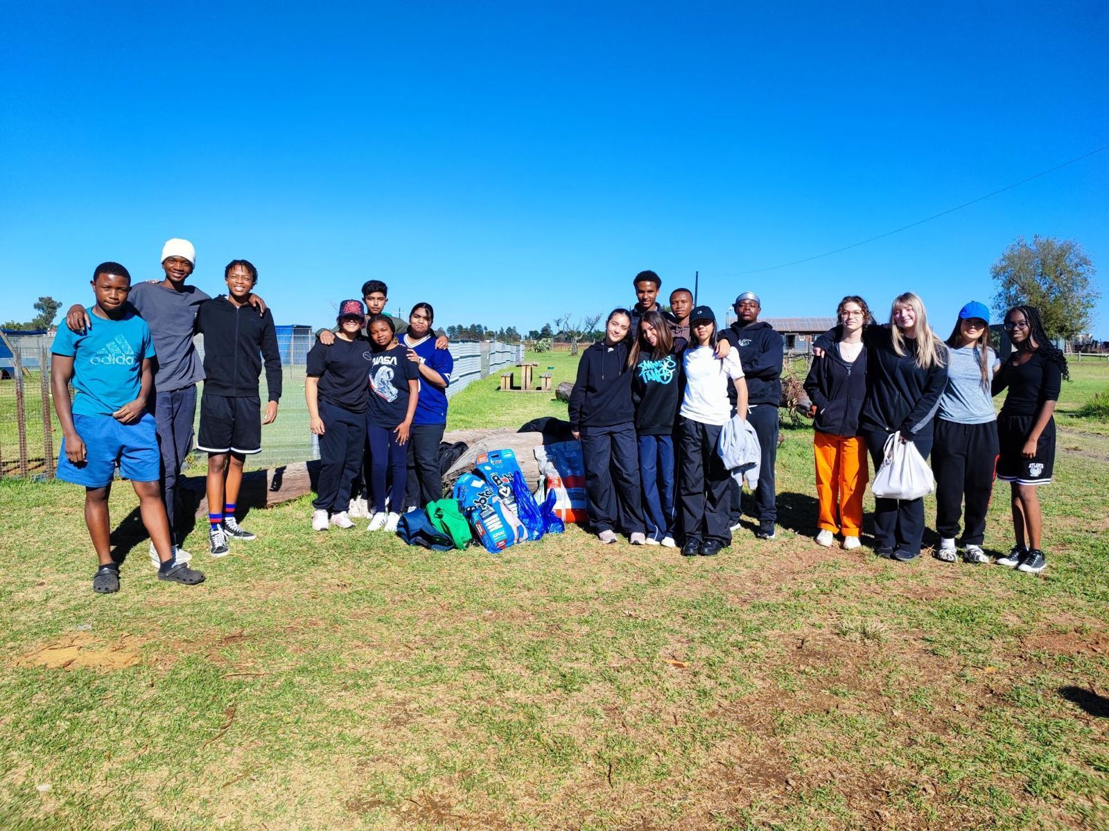 A group of people are posing for a picture in a field.