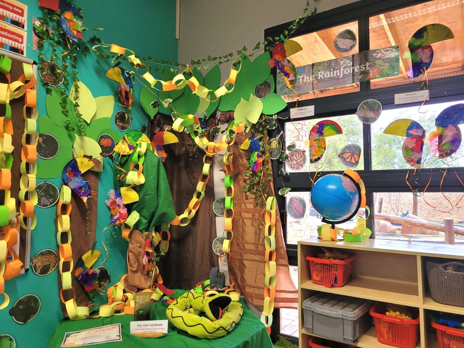 A room with a snake and a globe on a table.