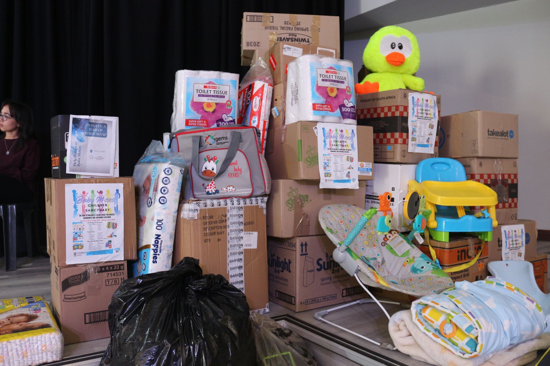 A pile of boxes and toys including a baby bouncer
