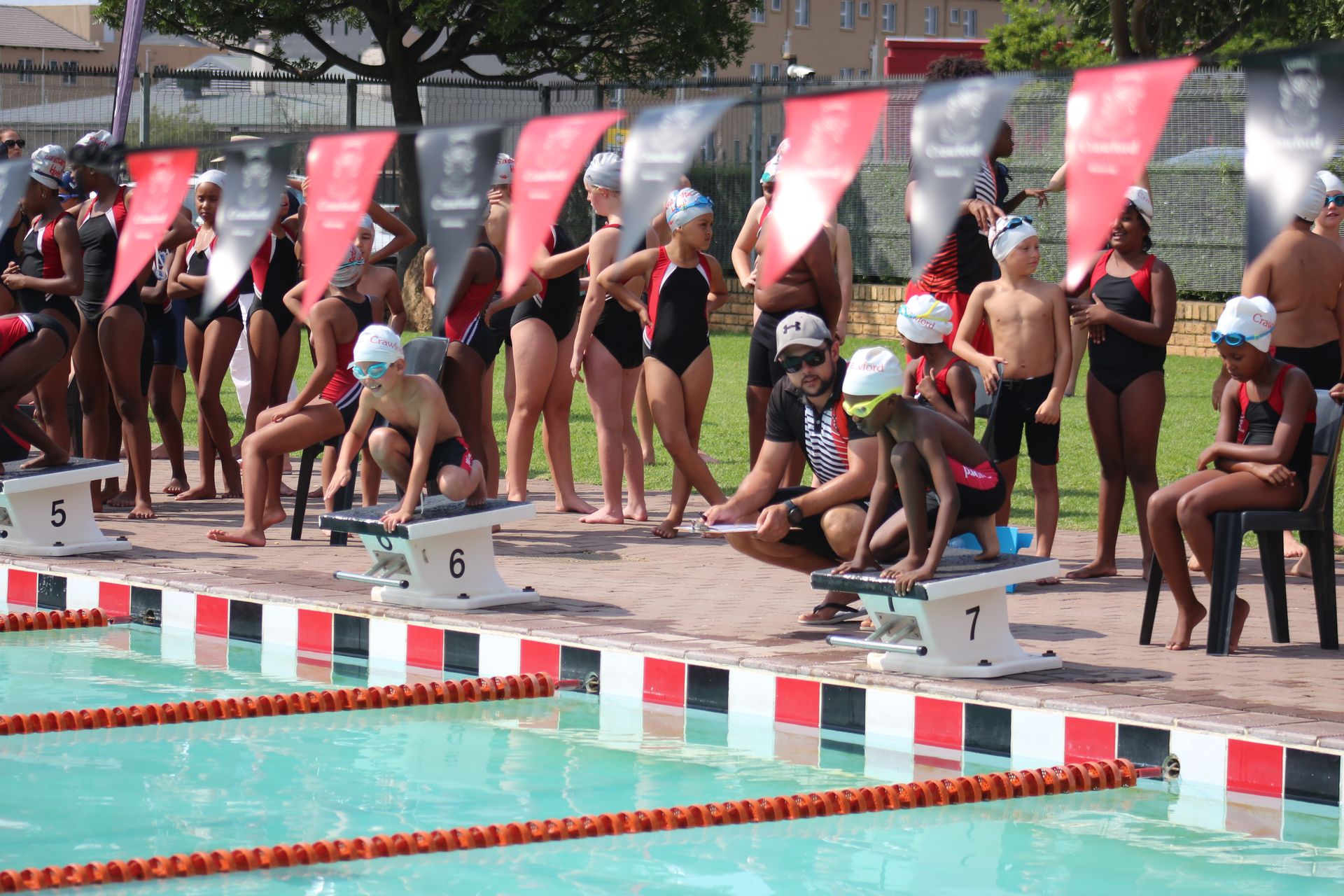 A group of people are standing around a swimming pool