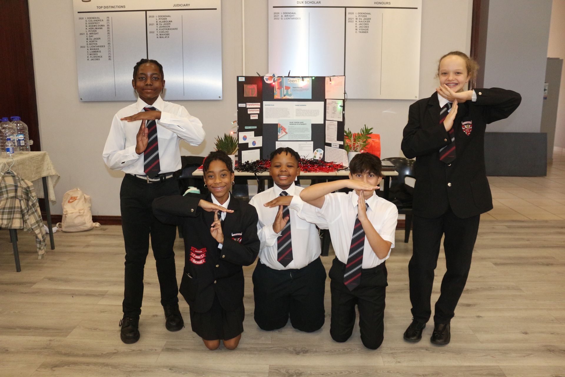 A group of children in school uniforms are posing for a picture.