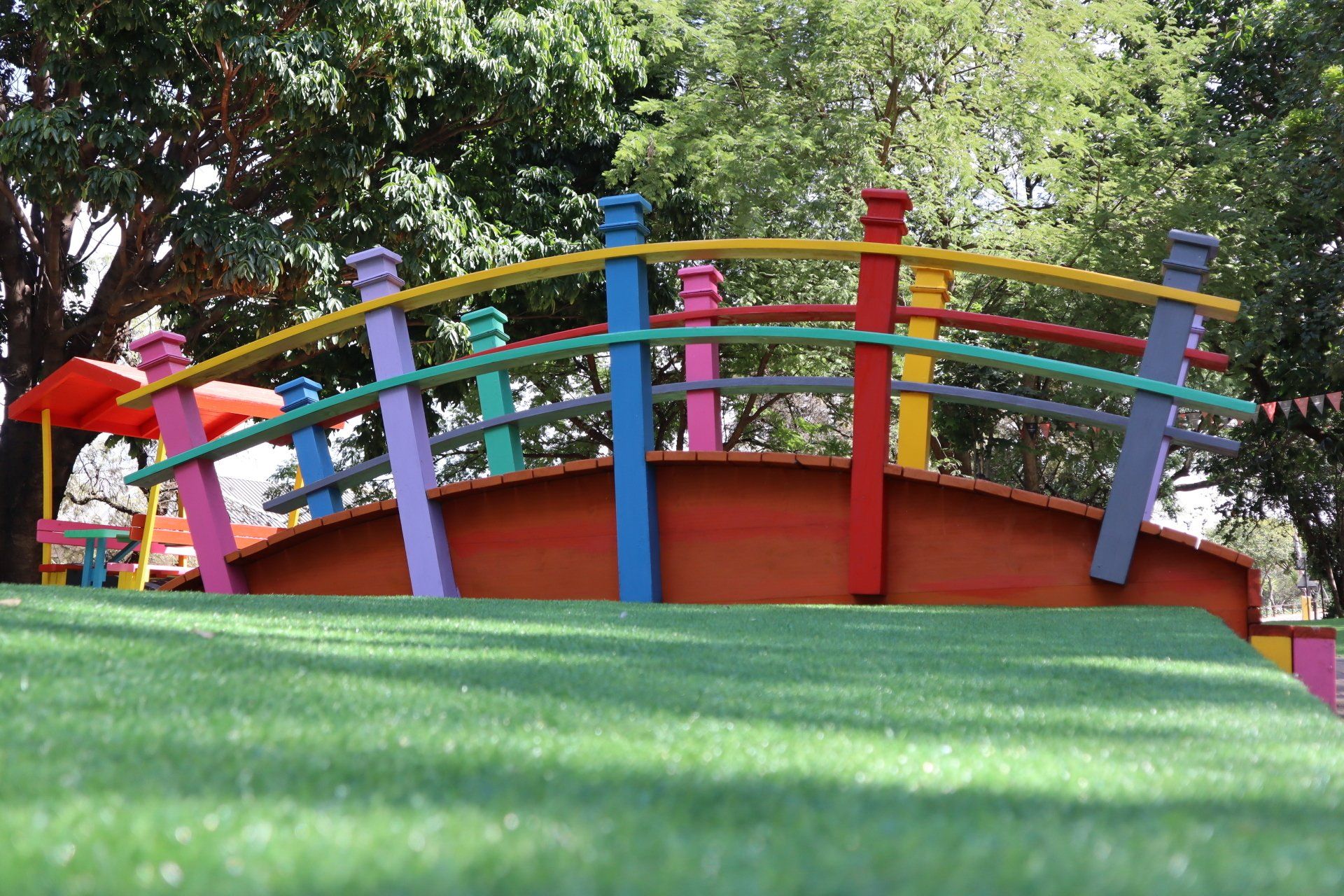 a colorful bridge on campus with trees in the background