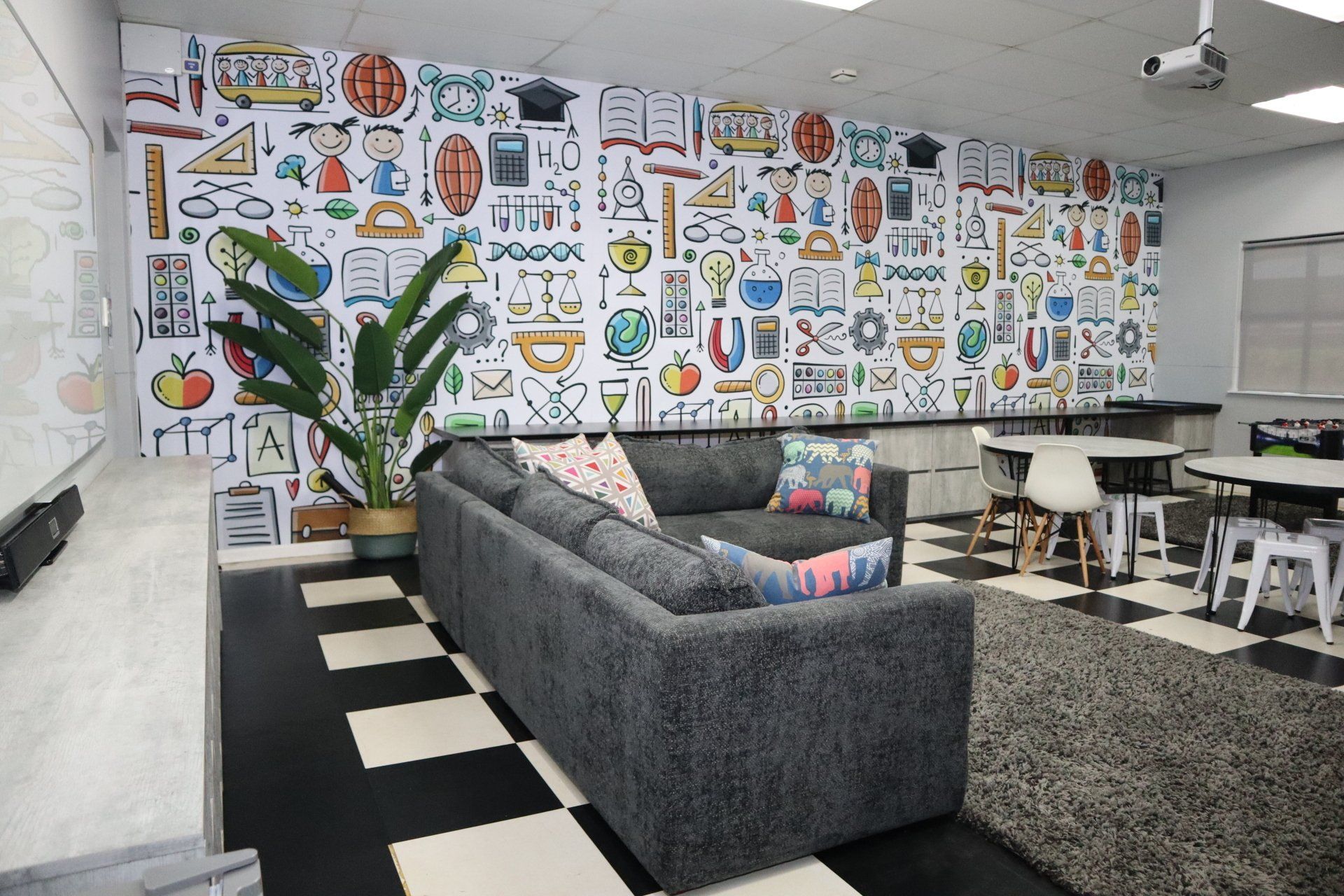 A living room with a couch and a mural on the wall.