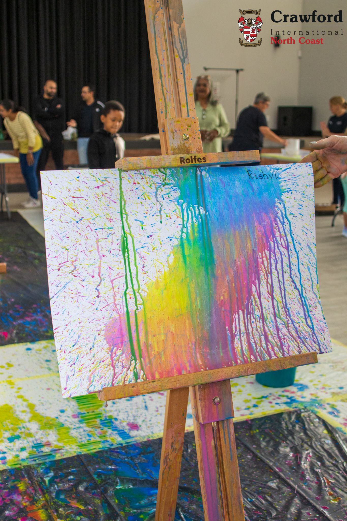 A painting on an easel with a rainbow of colors on it.