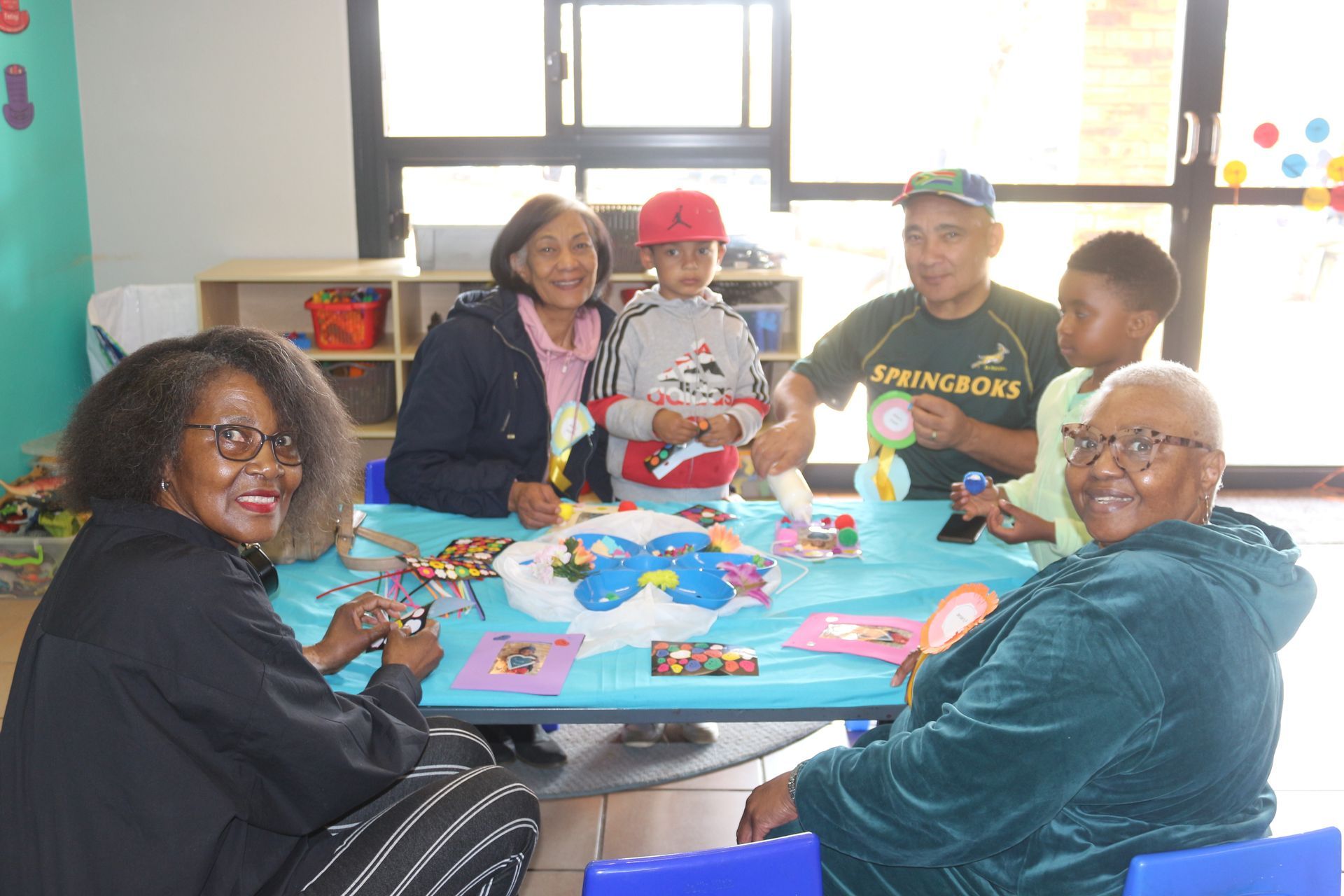 A group of people are sitting around a table making crafts.