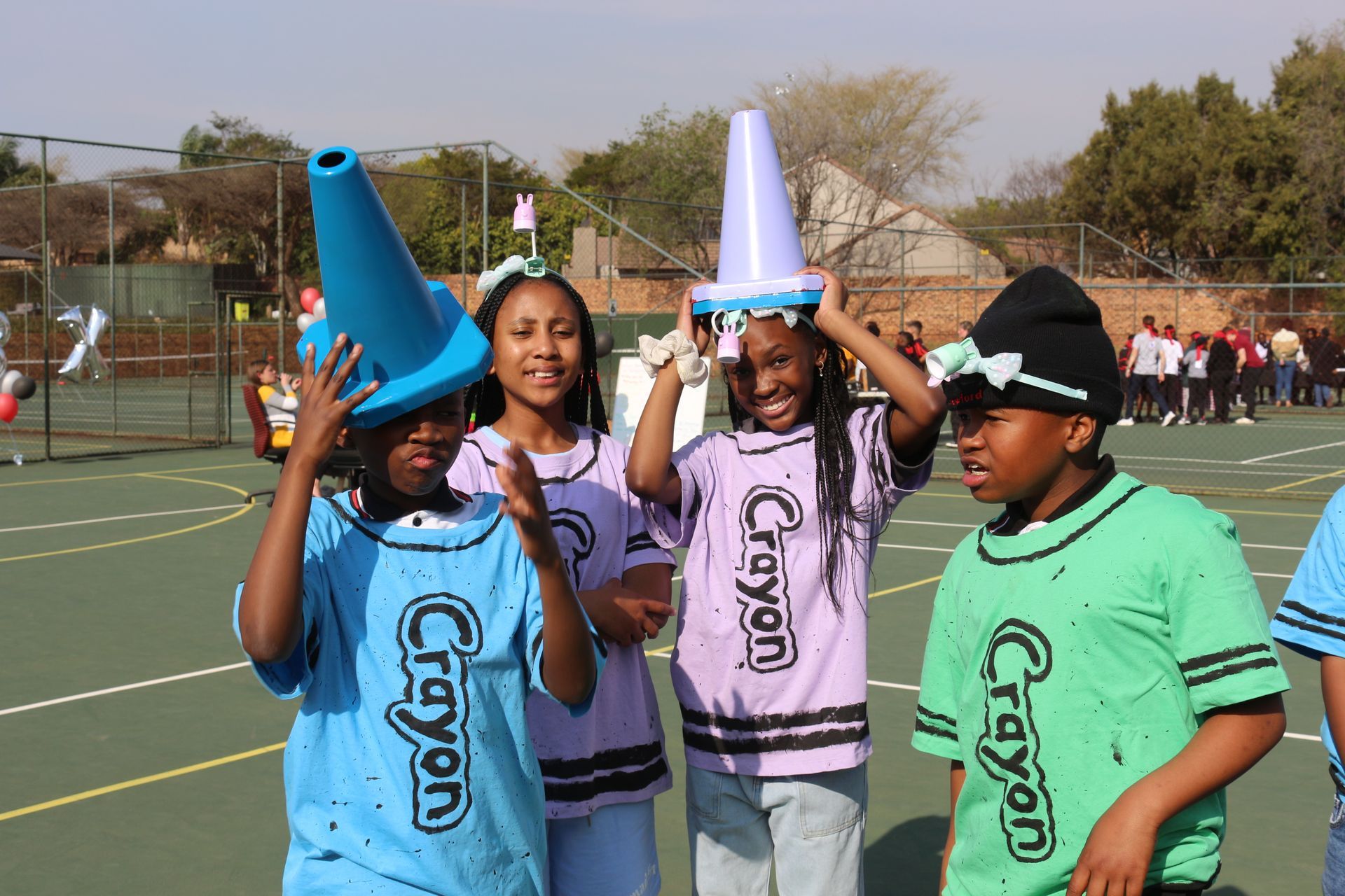 A group of children wearing crayon shirts are posing for a picture