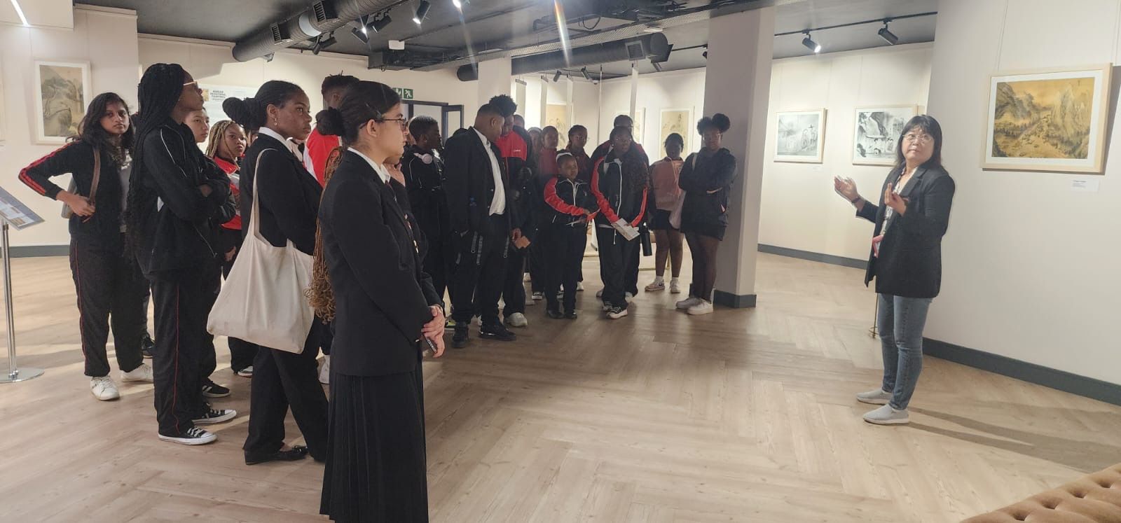 A woman is talking to a group of people in a museum.