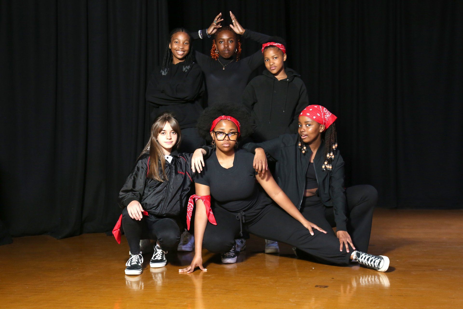a group of young girls are posing for a picture on a stage .