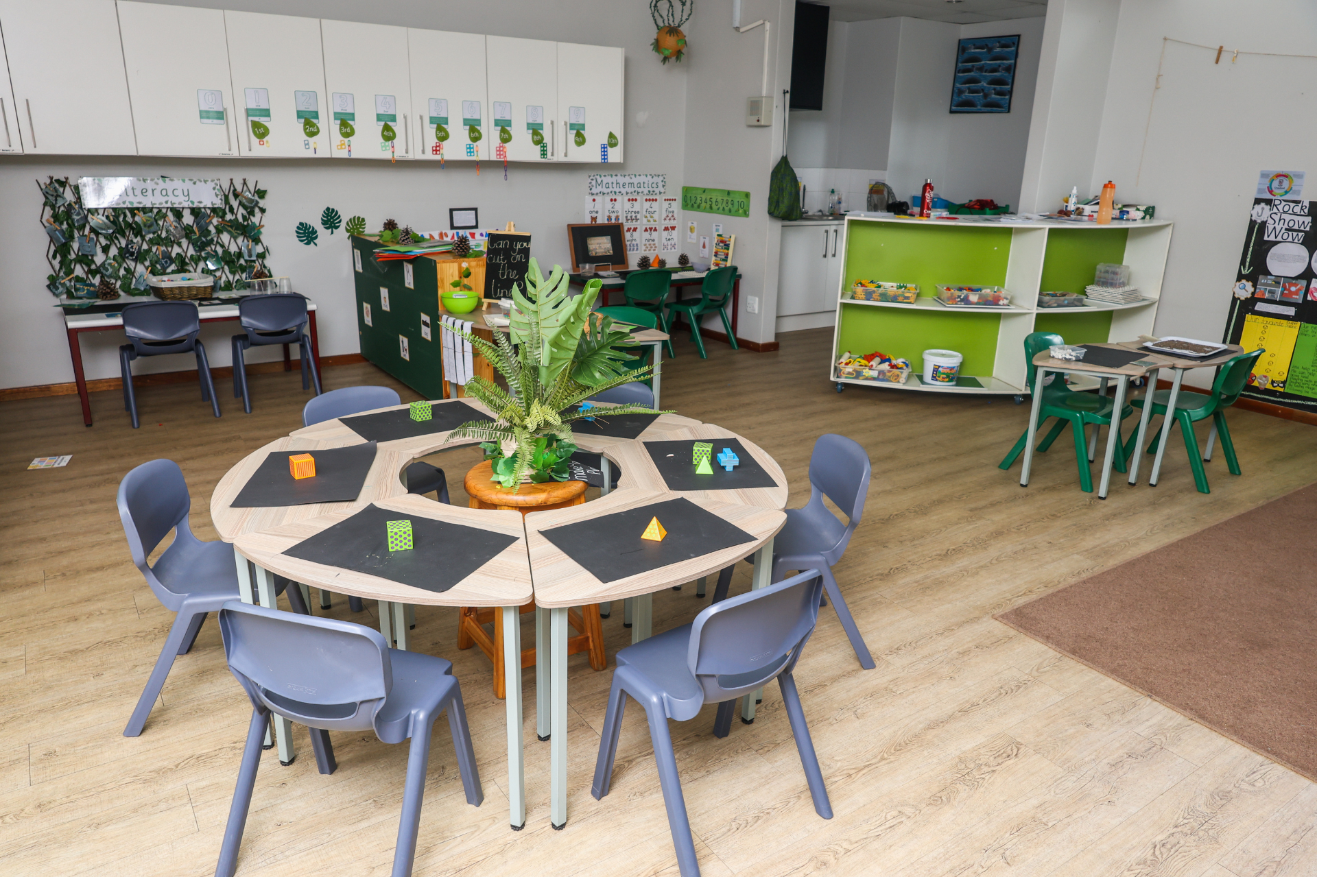 a classroom with tables and chairs and a sign on the wall