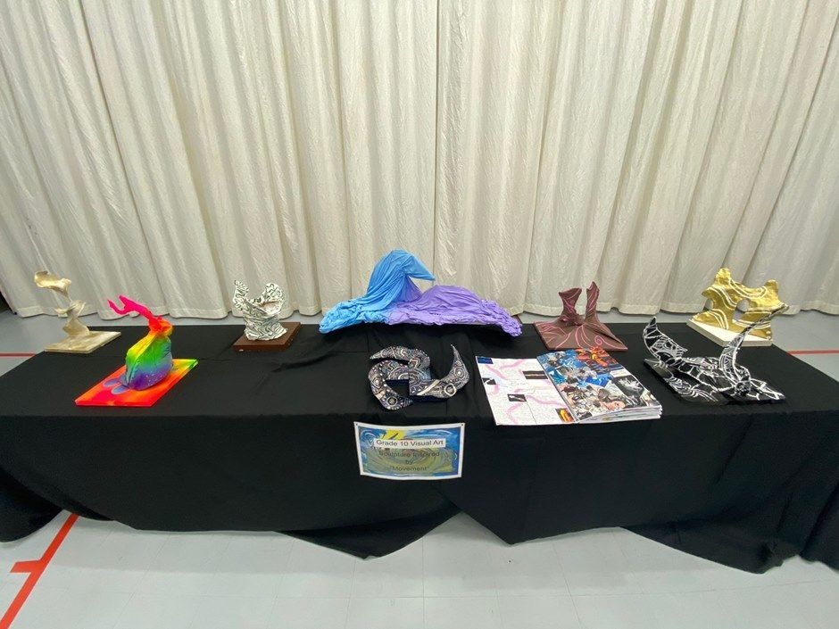 A table with a black table cloth and a bunch of sculptures on it.