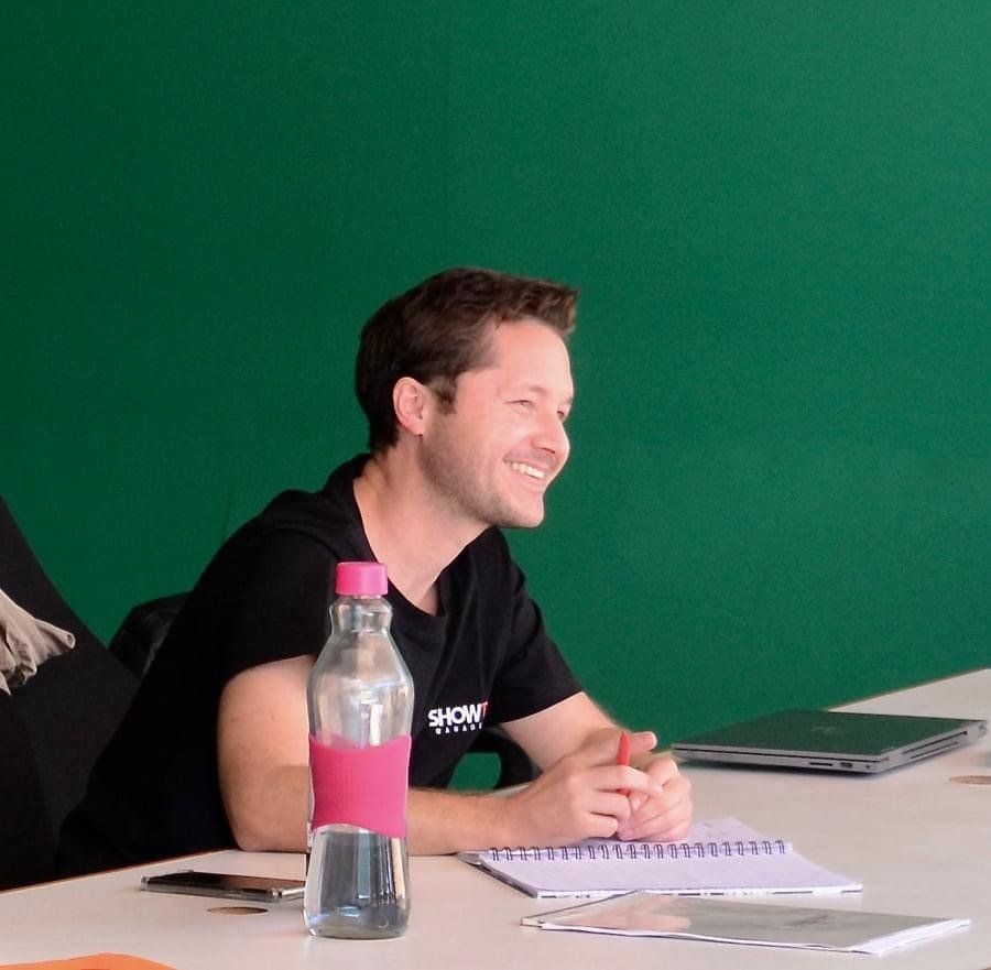 A man wearing a show shirt sits at a table