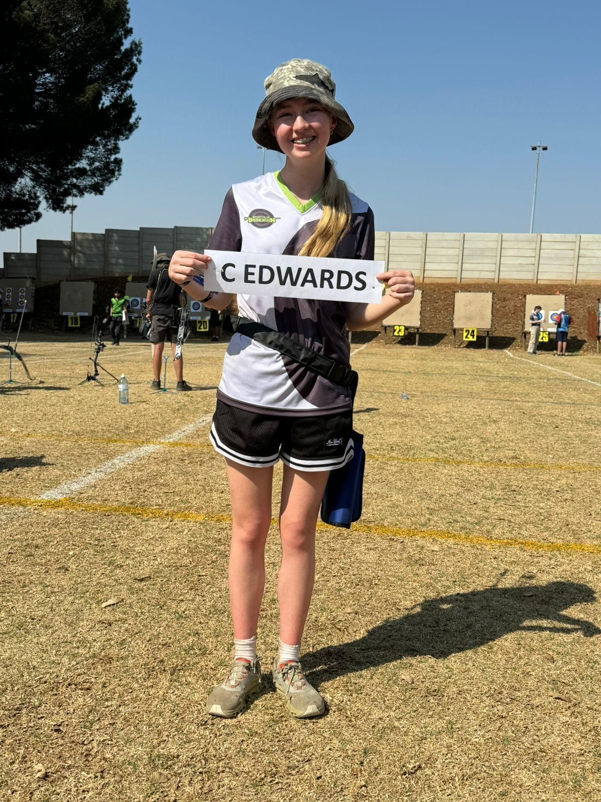 A young girl is holding a sign that says c edwards.
