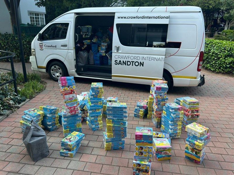 A white van is filled with lots of boxes of toys.
