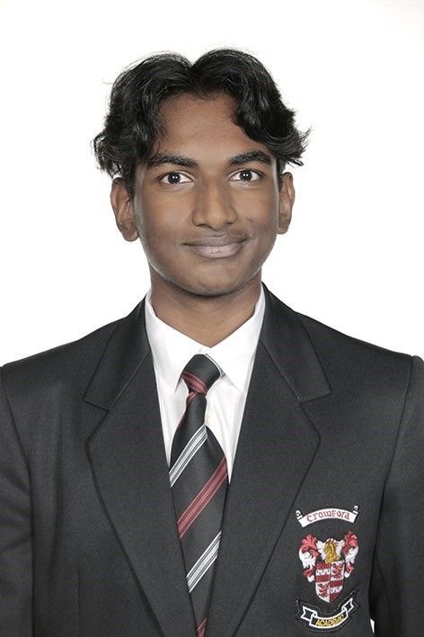 A young man in a suit and tie is smiling for the camera.