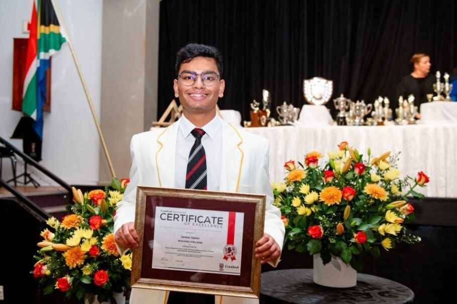 A man in a suit and tie is holding a certificate