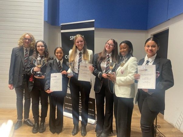 A group of people standing next to each other holding trophies and certificates.