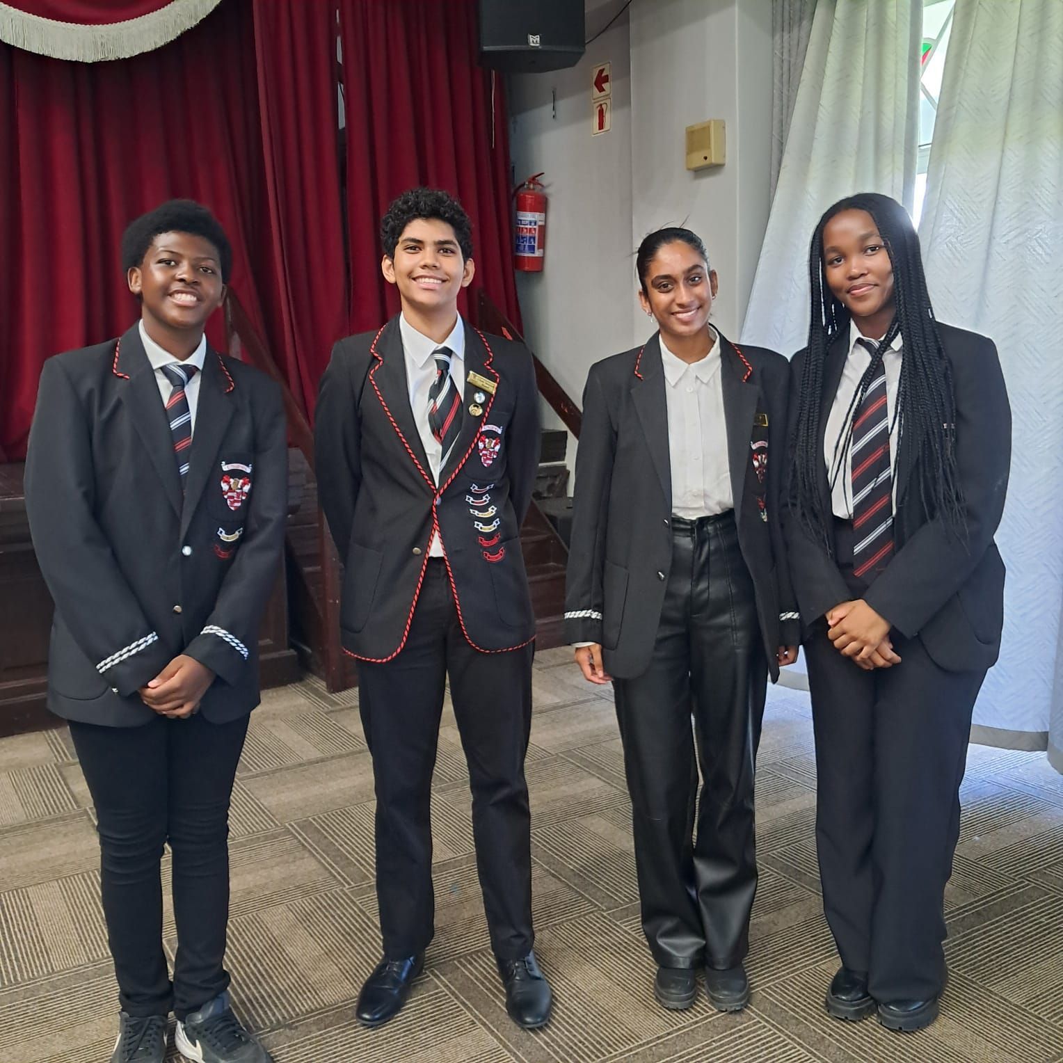 A group of young people in suits and ties are posing for a picture.