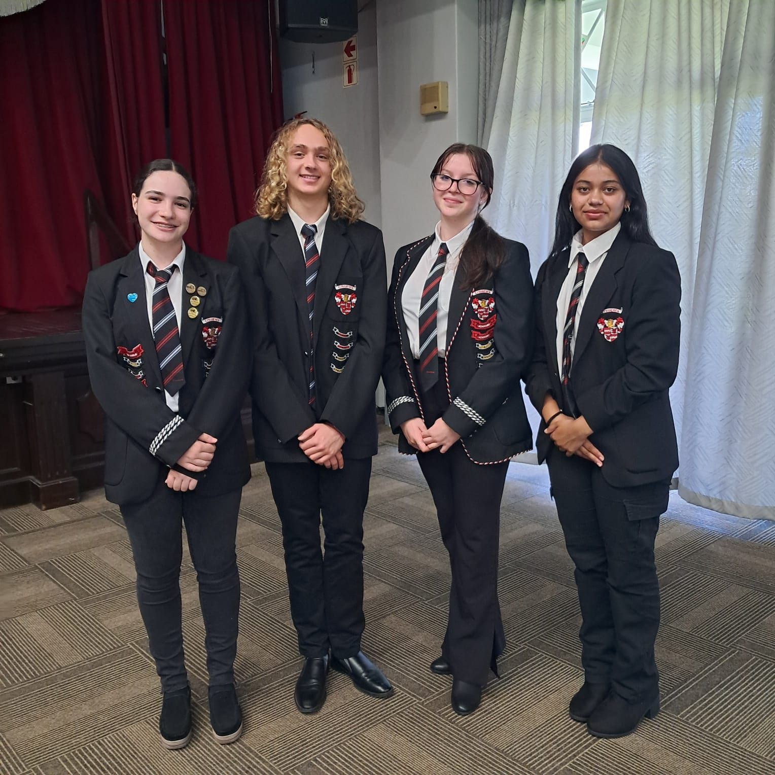 A group of young people in school uniforms are standing next to each other in a room.