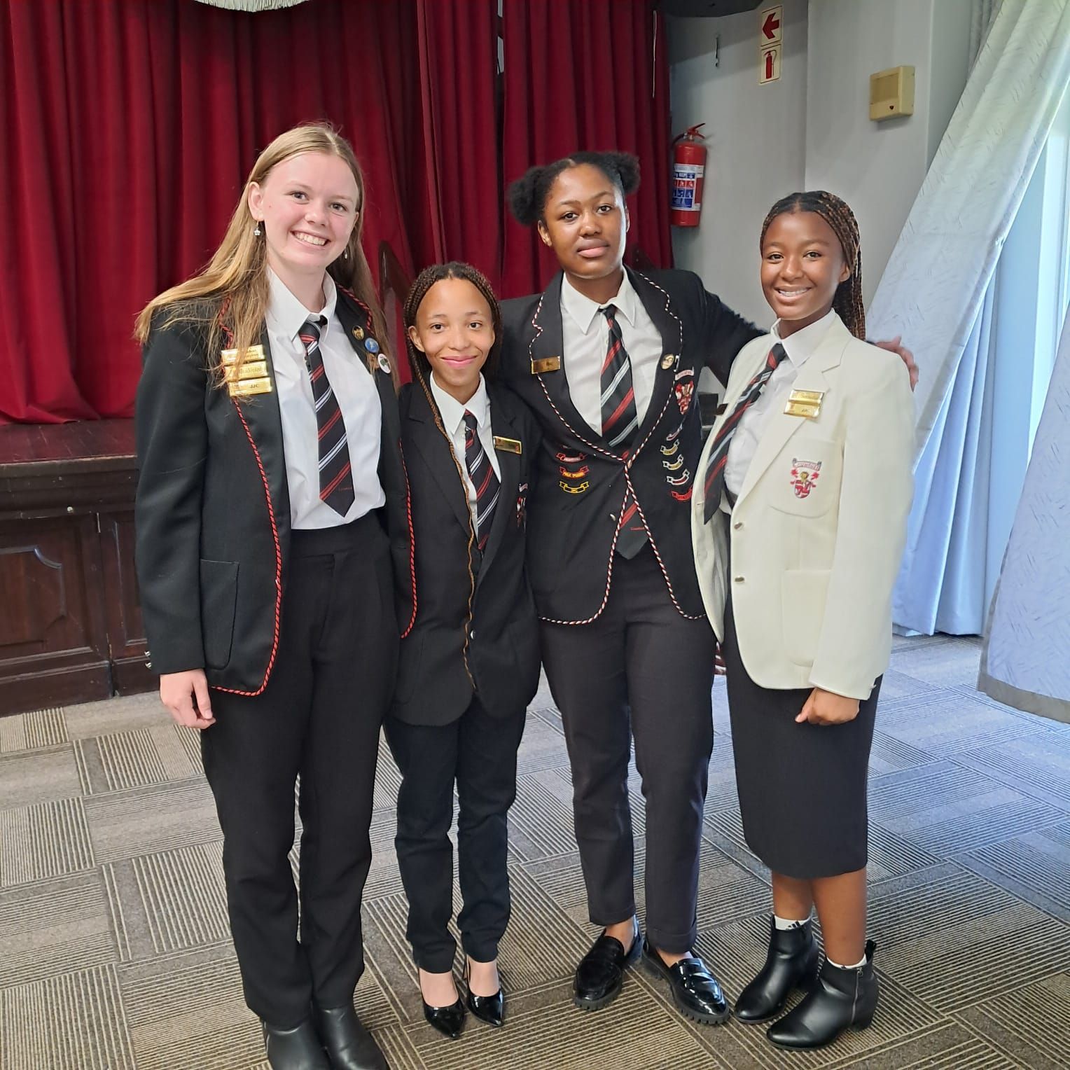 A group of young women in suits and ties are posing for a picture.
