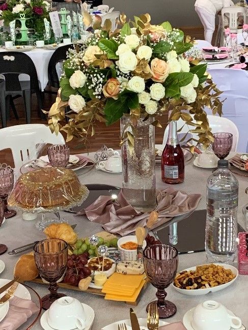 A table set for a party with a vase of flowers on it.