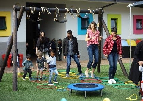 A group of people are playing on a playground with a trampoline.