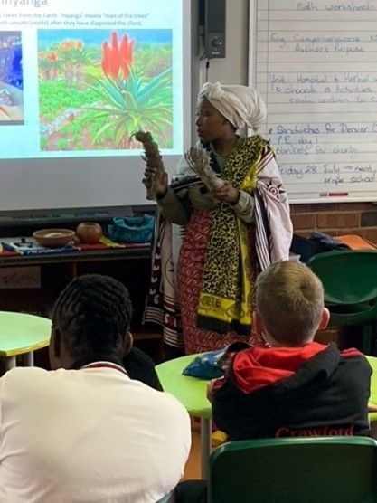 A woman is giving a presentation to a group of children