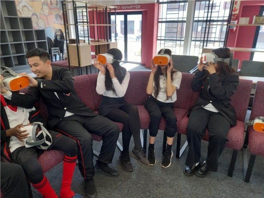 A group of people are sitting in chairs wearing virtual reality headsets