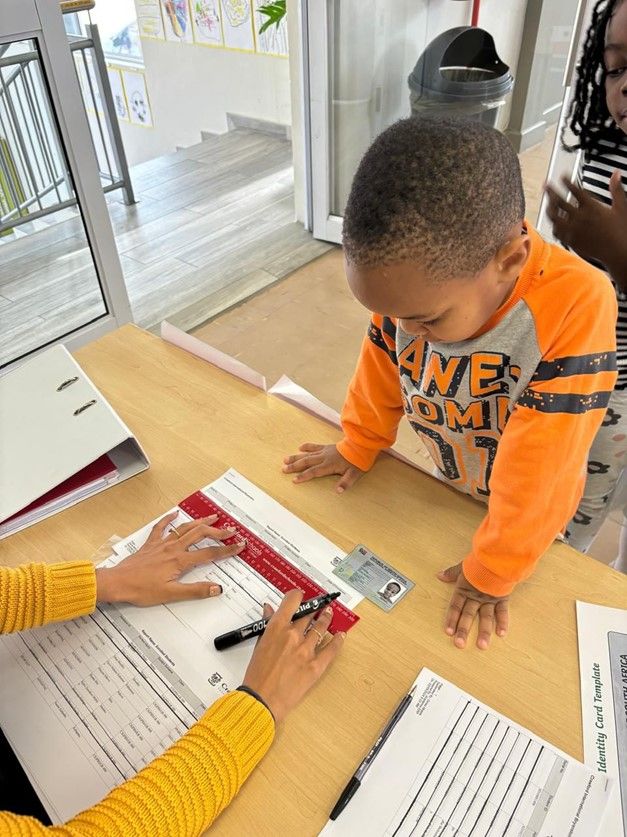 A little boy is sitting at a table with a woman.