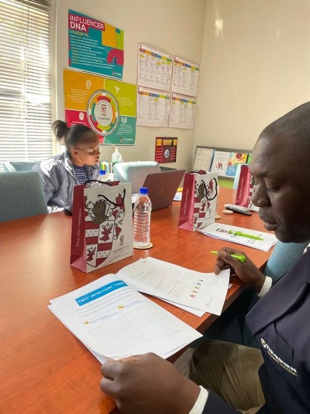 A man and a woman are sitting at a table with papers on it.
