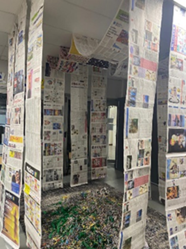 A room filled with lots of newspapers hanging from the ceiling.