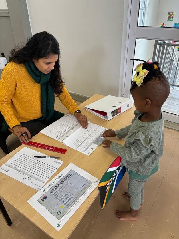 A woman is sitting at a table with a child.