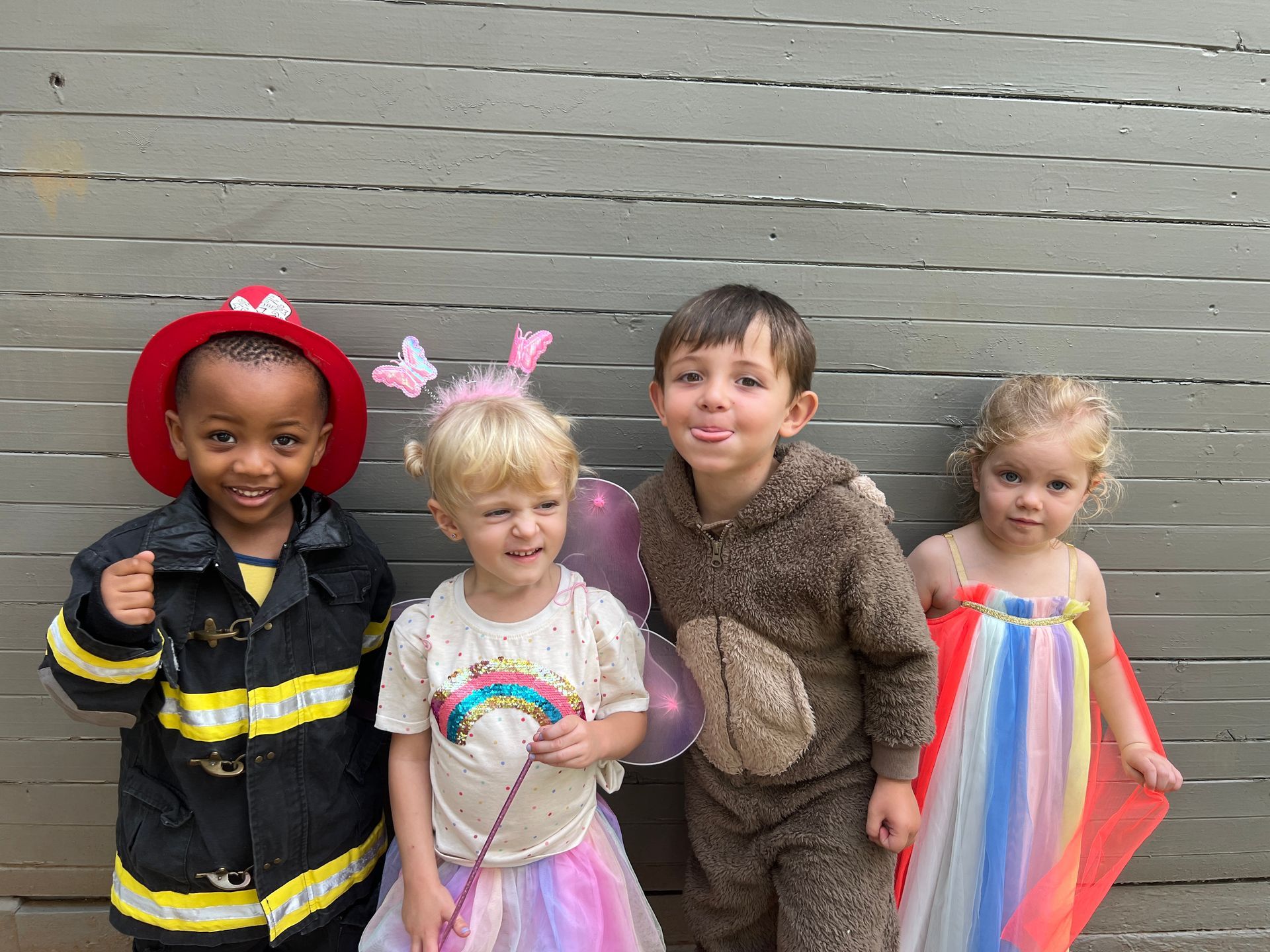 A group of children dressed in costumes are standing next to each other.