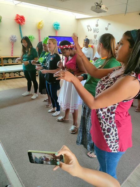 A woman is taking a picture of a group of people dancing