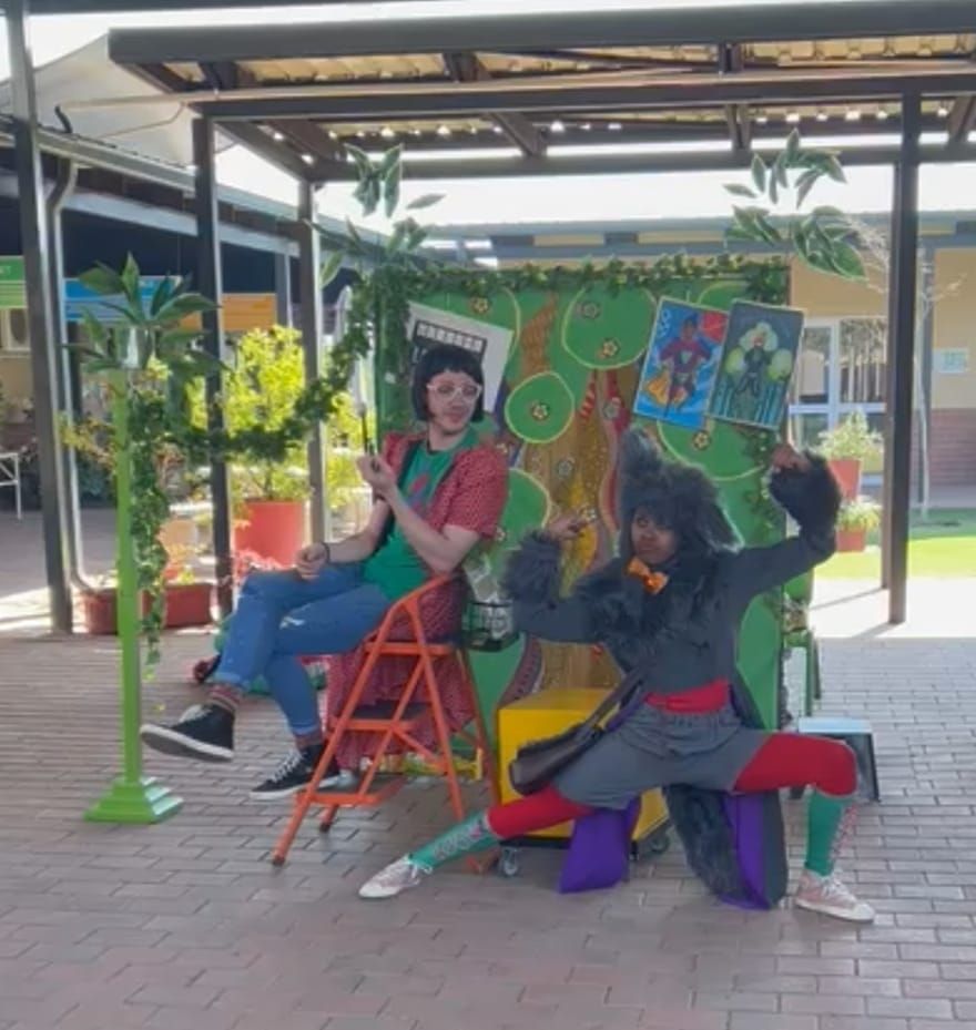 A man is sitting on a ladder next to a woman in a monkey costume