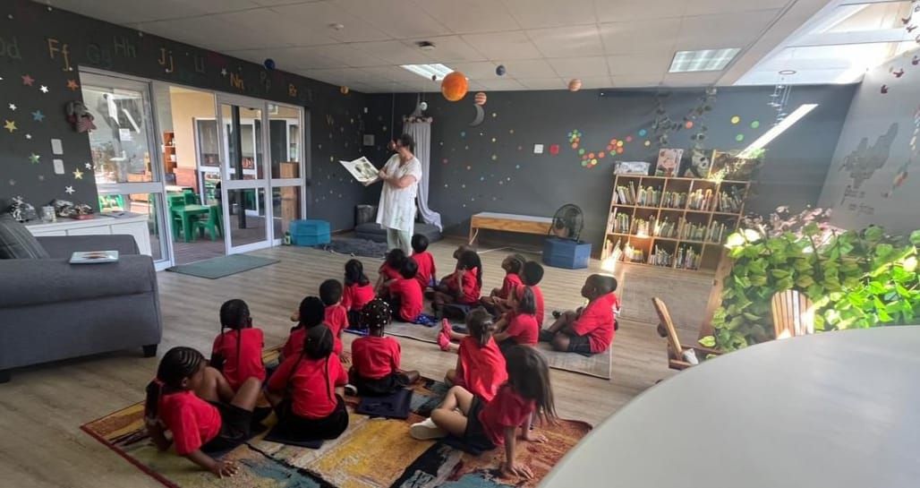 A group of children are sitting on the floor in a room.