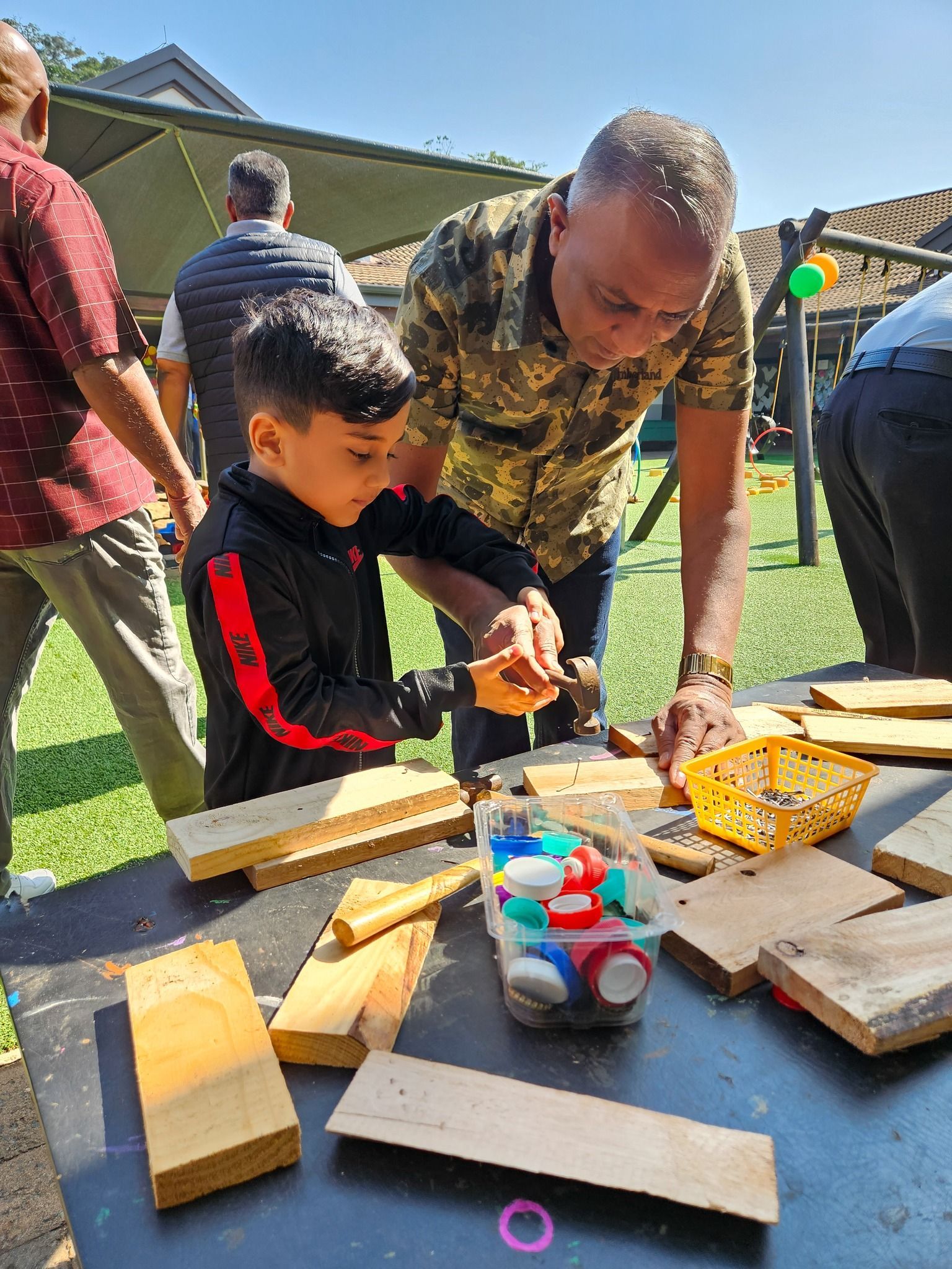 A man and a boy are playing with wooden blocks at a table.