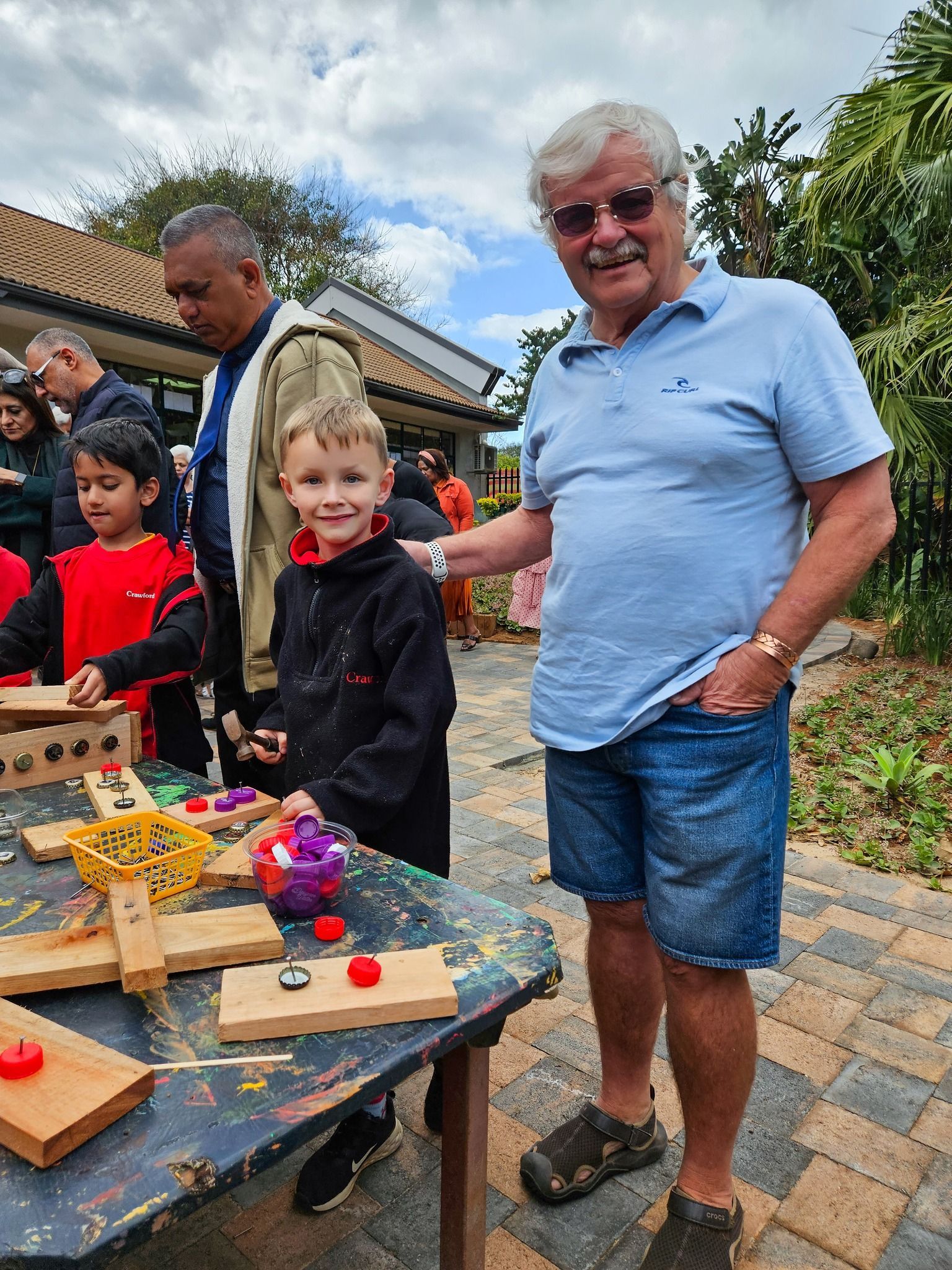 A man and a boy are standing next to a table with toys on it.