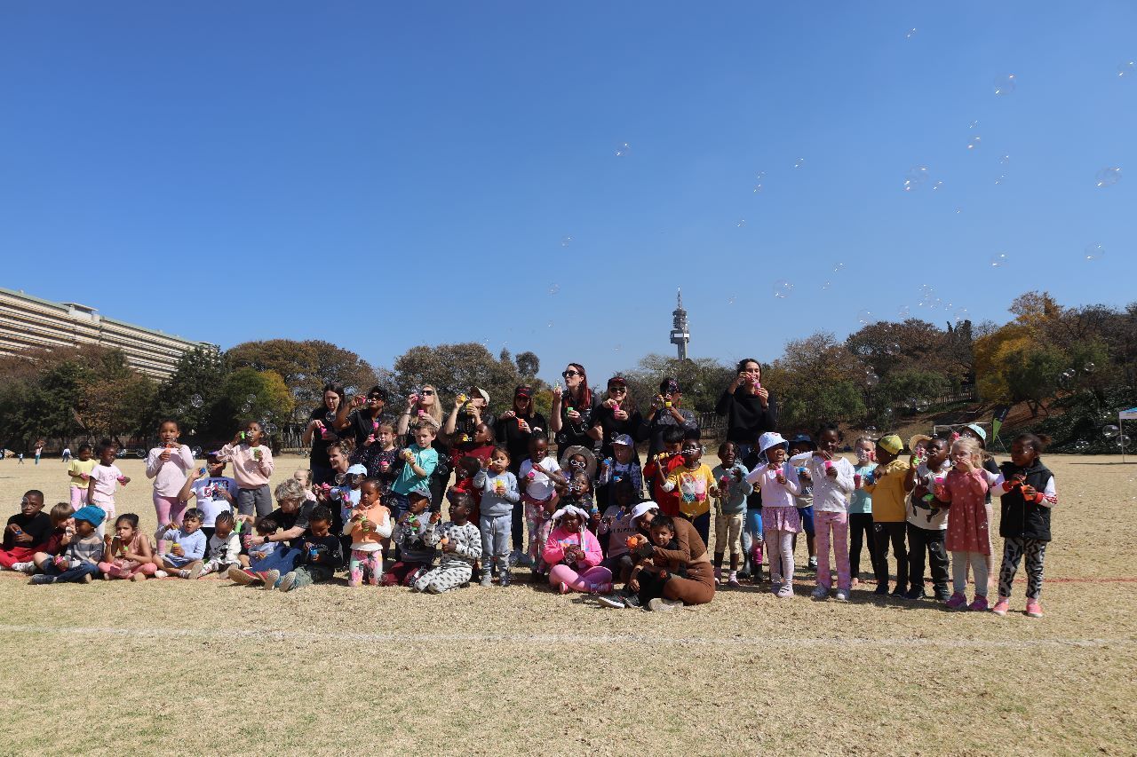 A group of children are posing for a picture in a field.