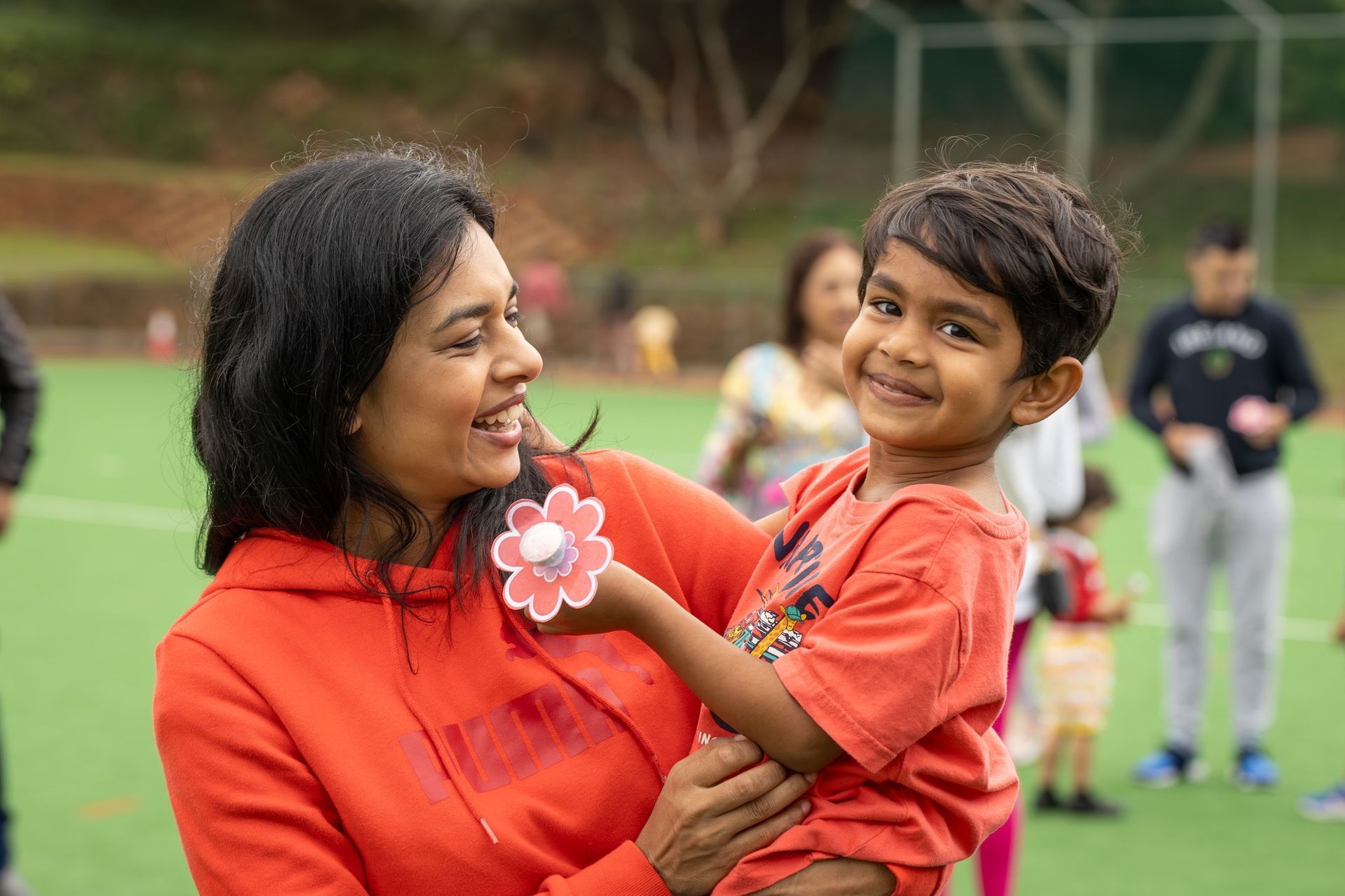 A woman is holding a young boy in her arms.