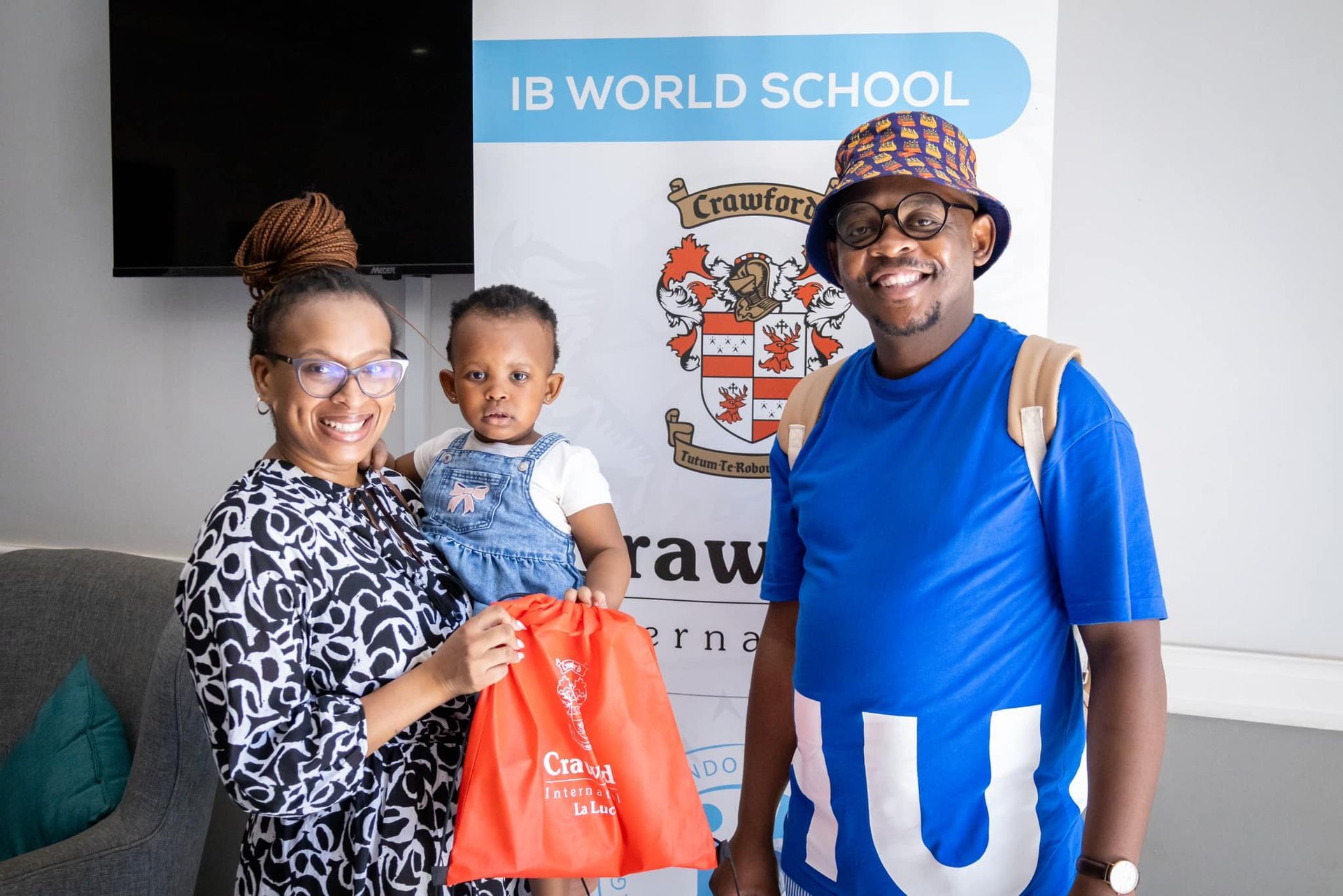 Family with a child holding a gift bag in front of an 