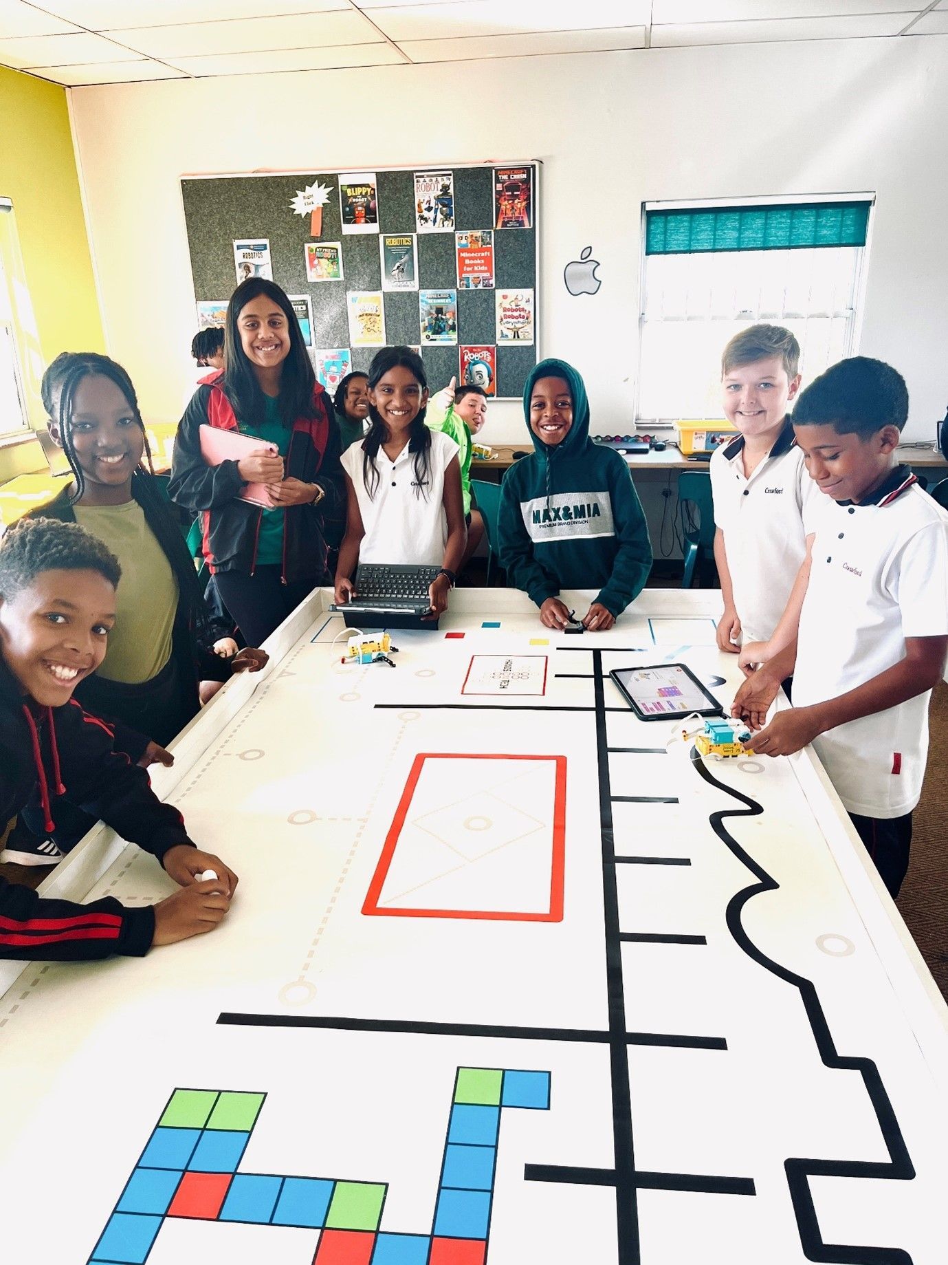 A group of children are sitting around a table in a classroom.