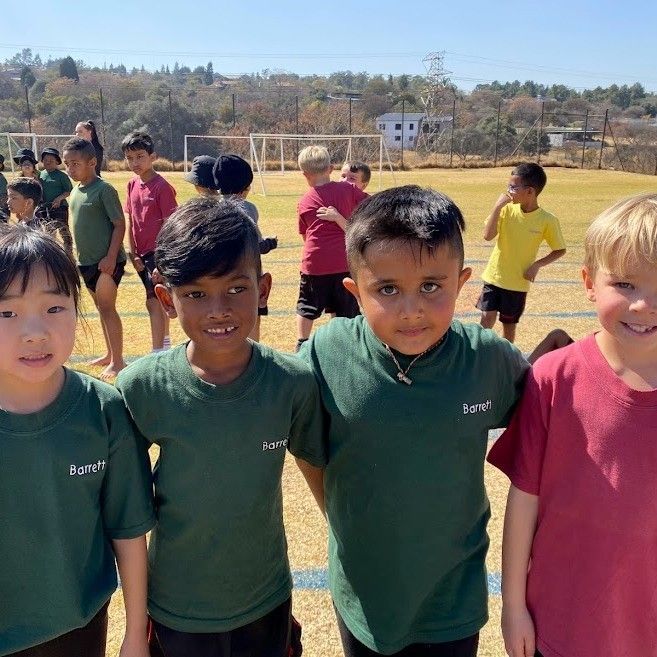 A group of young boys are posing for a picture on a field.