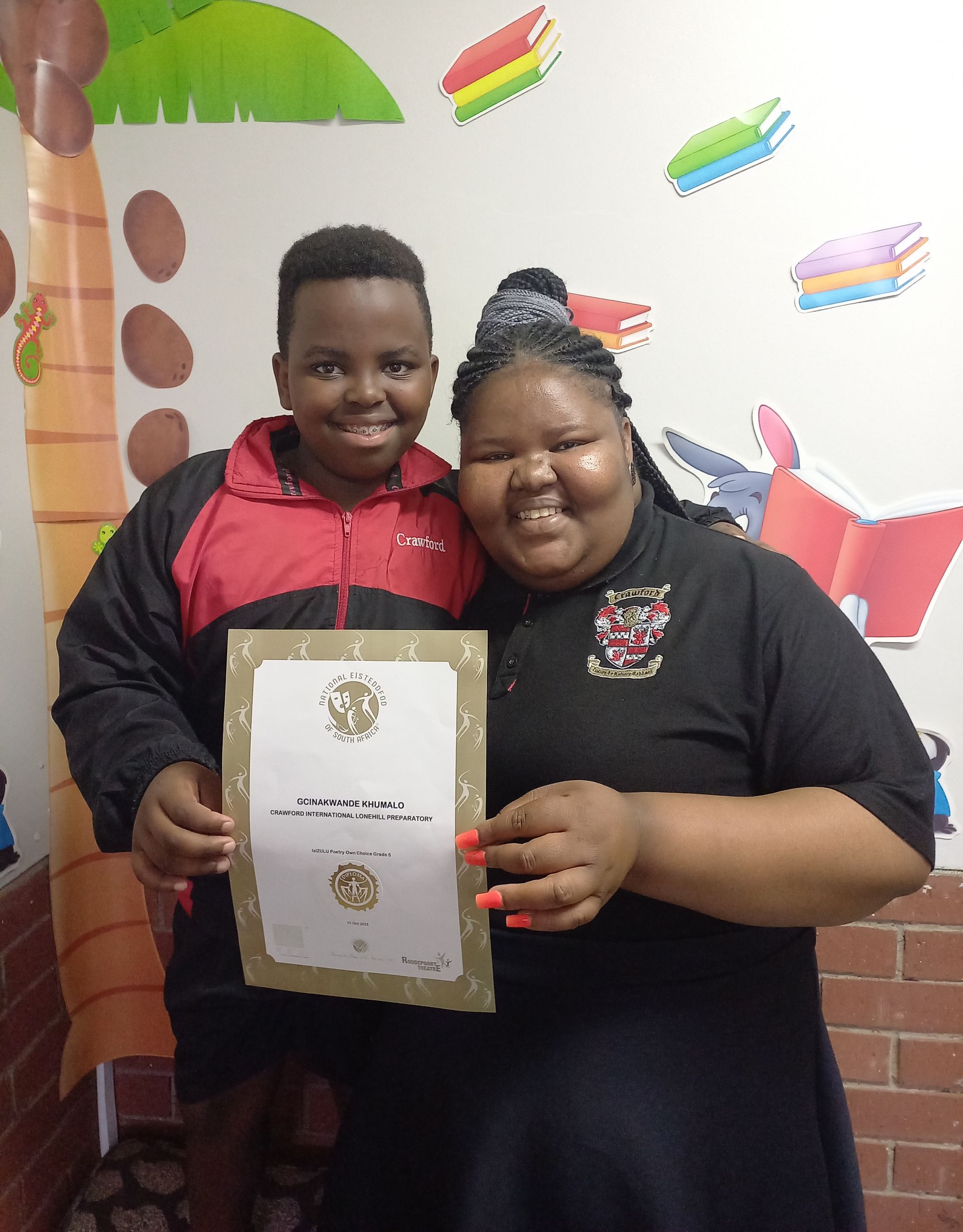 A boy and a girl are posing for a picture while holding a certificate.