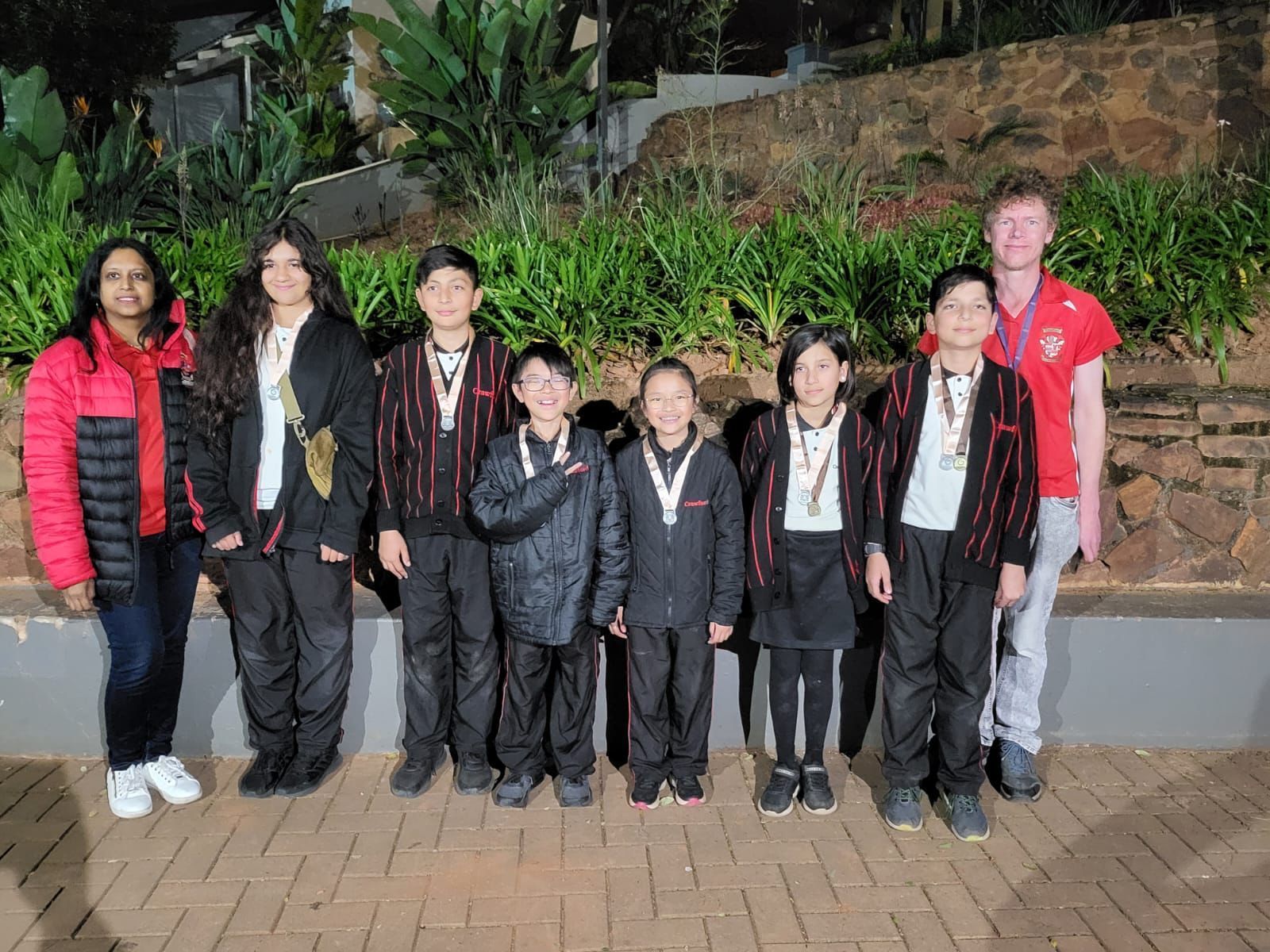 A group of children in school uniforms are posing for a picture.
