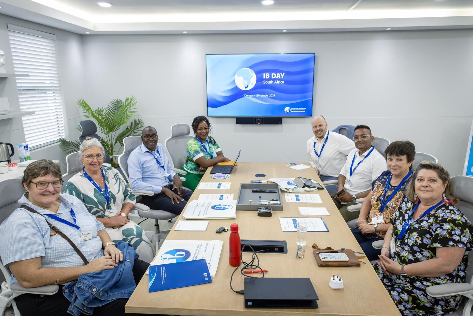 A group of people are sitting around a long table in a conference room.