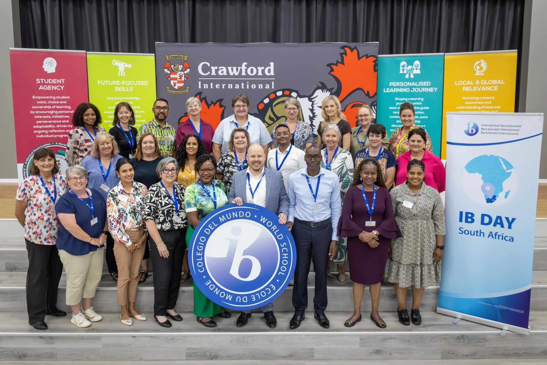 A group of people are posing for a picture in front of a crawford sign.