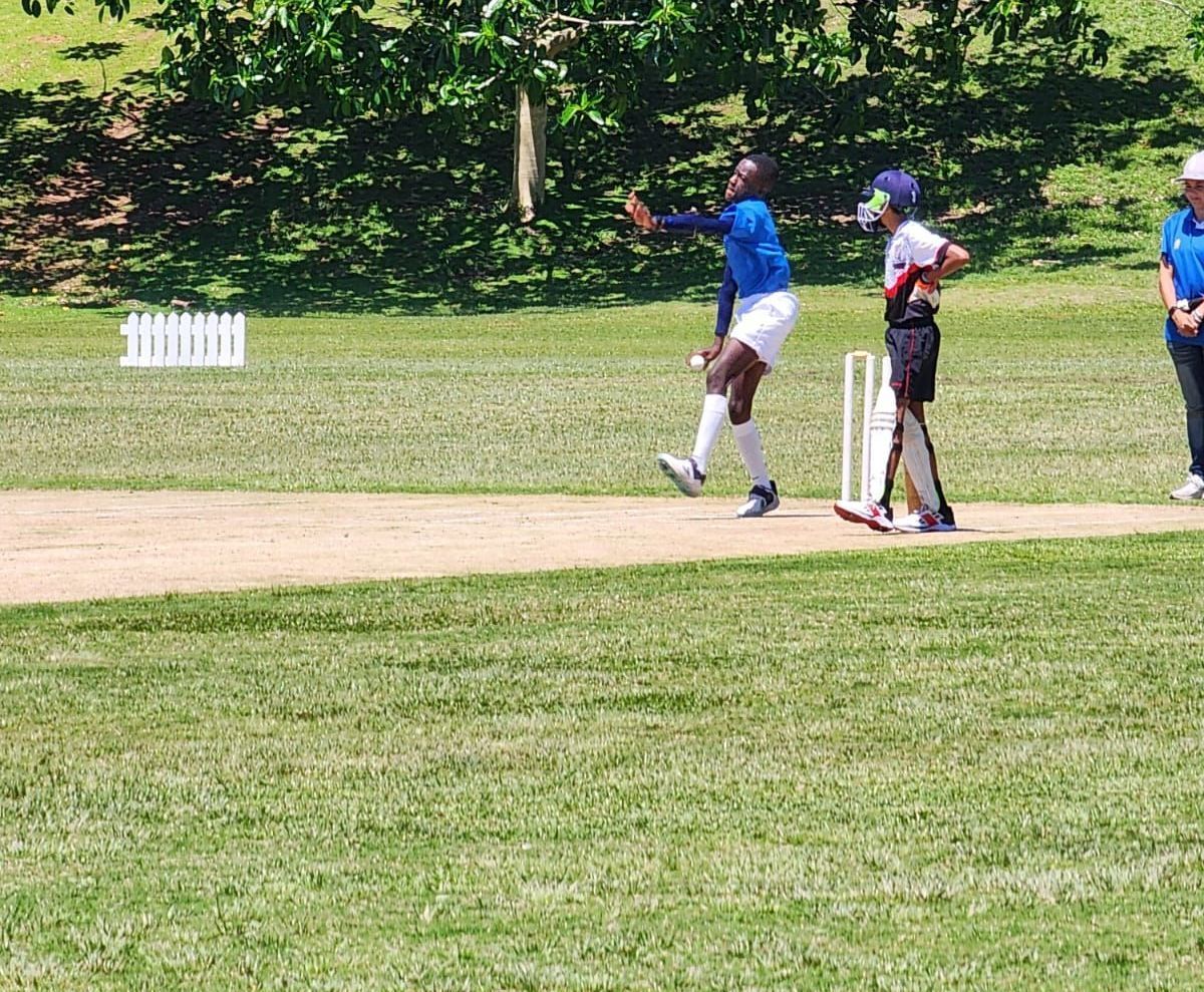 A group of people are playing a game of cricket on a field.