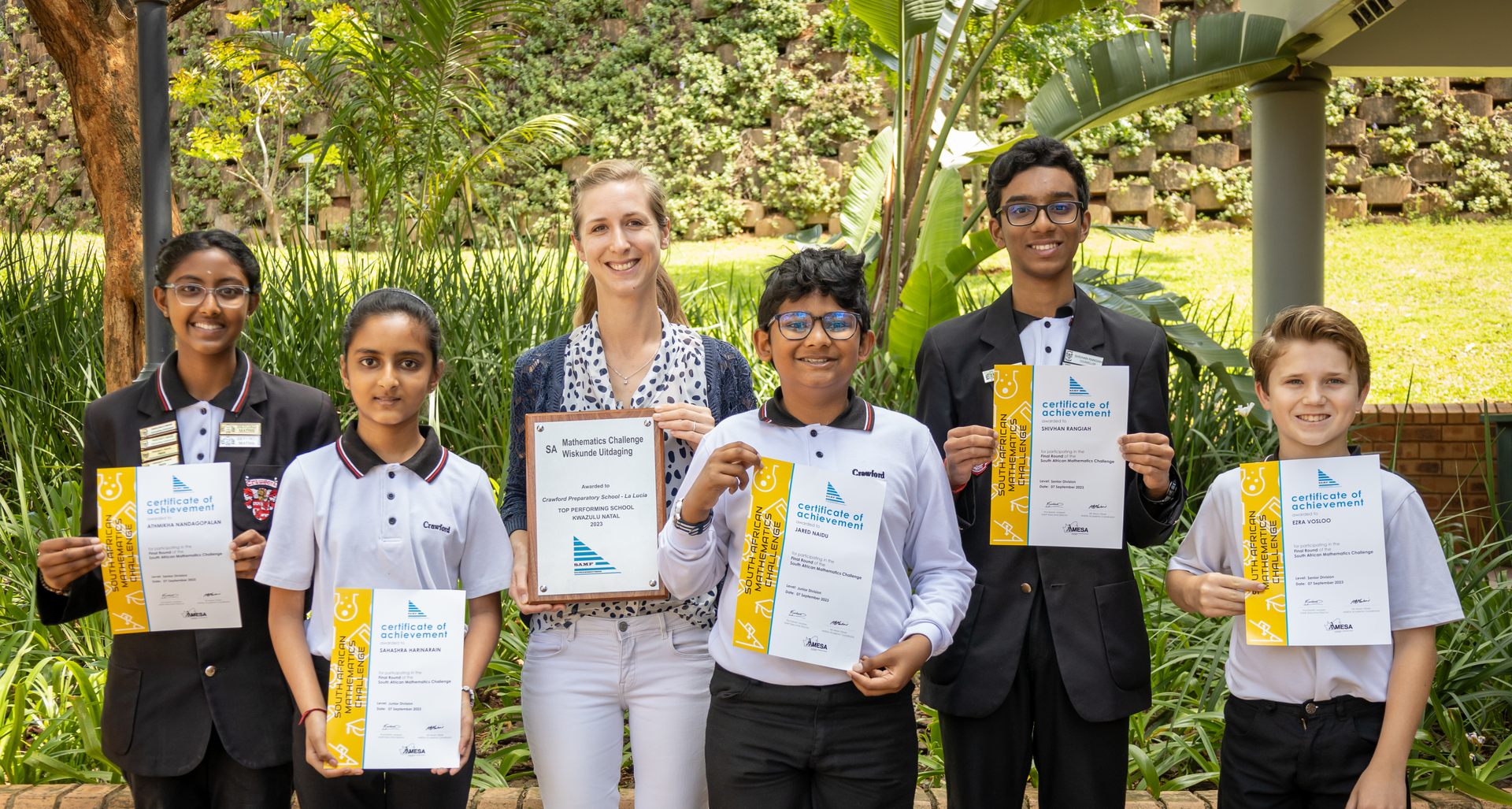 A group of young people are standing next to each other holding certificates.