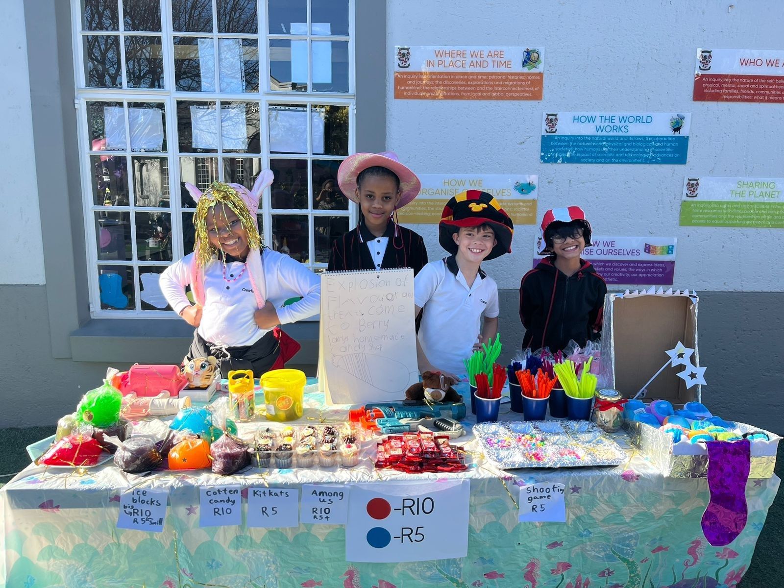 A group of children are standing around a table with toys on it.